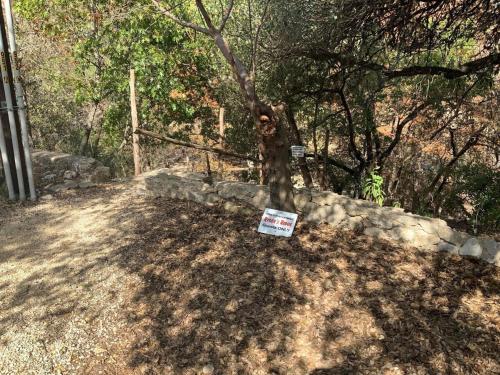 a sign sitting on the ground next to a tree at Ryder's Ridge in Concan
