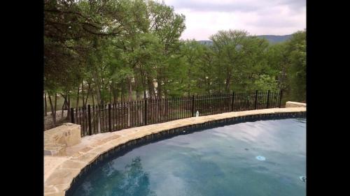 a large swimming pool with a fence and trees at Ryder's Ridge in Concan