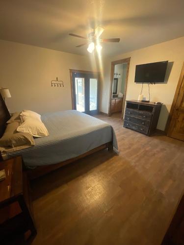 a bedroom with a bed and a flat screen tv at Ryder's Ridge in Concan