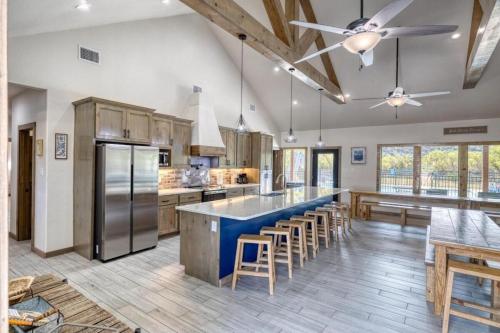a kitchen with a large island with bar stools at River Ridge in Concan