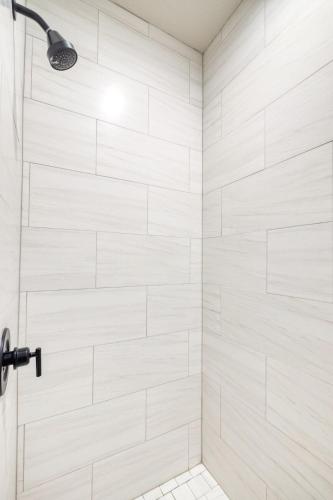 a bathroom with a shower with white tile at River Ridge in Concan