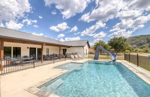 a swimming pool with a slide in a house at River Ridge in Concan
