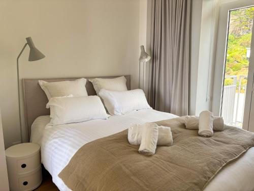 une chambre avec un grand lit avec des draps et des oreillers blancs dans l'établissement PORS-MABO T3, Luxury 2 Bedroom Apartment with Sea, à Trébeurden