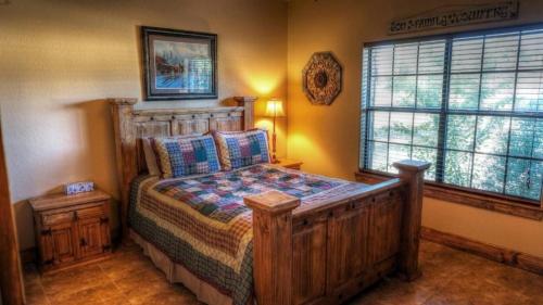 a bedroom with a wooden bed and a window at River Dance in Concan