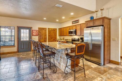 a kitchen with a counter with chairs and a refrigerator at Rockin' Rio in Concan