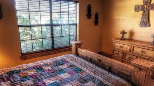 a bedroom with a bed and a cross on the wall at River Dance in Concan