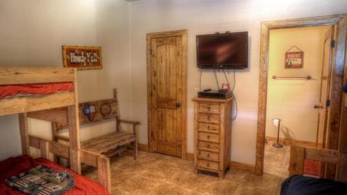 a bedroom with a bunk bed and a tv on the wall at River Dance in Concan