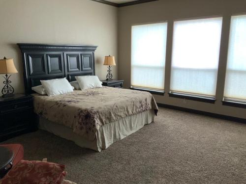 a bedroom with a bed with two pillows and windows at Big Cinchin' in Concan