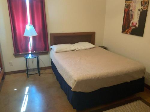 a bedroom with a bed and a lamp and a window at Double L River House in Concan