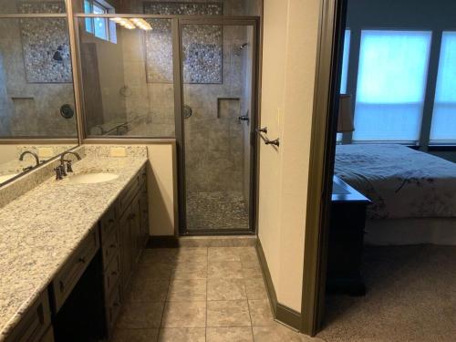 a bathroom with a shower and a sink and a bed at Big Cinchin' in Concan