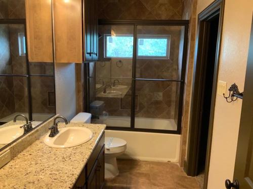 a bathroom with a sink and a toilet and a window at Big Cinchin' in Concan