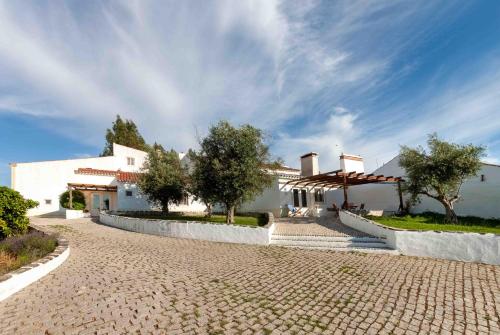a cobblestone street in front of a white house at Monte das Oliveiras - Casas de Campo in Estremoz