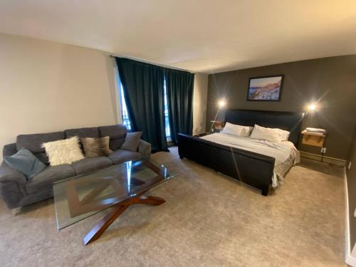 a living room with a bed and a couch at Close To Whyte University New Renovation in Edmonton