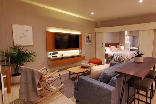 a living room with a couch and a tv and a bedroom at BEACH FRONT CONDO, PRIVATE BEACH and AMAZING VIEWS!! in Los Cuatro Hermanos