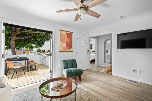 a living room with a ceiling fan and a table at Urban Spanish Bungalow in San Diego