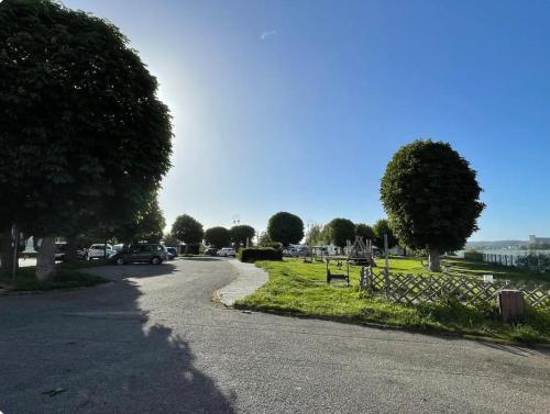 a winding road with cars parked on the side of the road at Ancienne maison de pêcheur atypique in Quillebeuf-sur-Seine