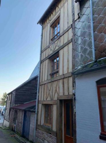 an old brick building with windows on a street at Ancienne maison de pêcheur atypique in Quillebeuf-sur-Seine