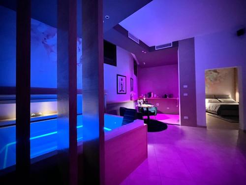 a room with pink and blue lights in a bedroom at Sumaiè Suite - Wellness in Salento in Mesagne