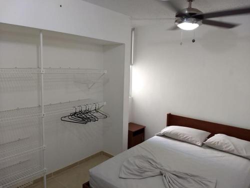 a bedroom with a bed and a ceiling fan at occidente Santa Fe de Antioquia sol y playa in Santa Fe de Antioquia