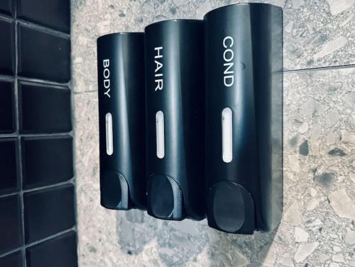 a group of black batteries hanging on a wall at Condo Magico en Revolucion TJ in Tijuana