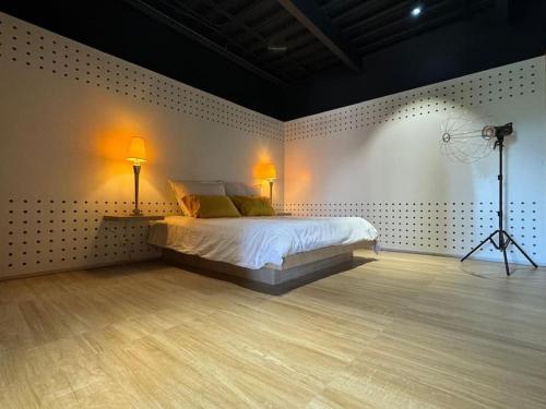 a bedroom with a bed with two lamps and a camera at Condo Magico en Revolucion TJ in Tijuana