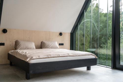 a bed in a room with a large window at Pine chalet in Smižany