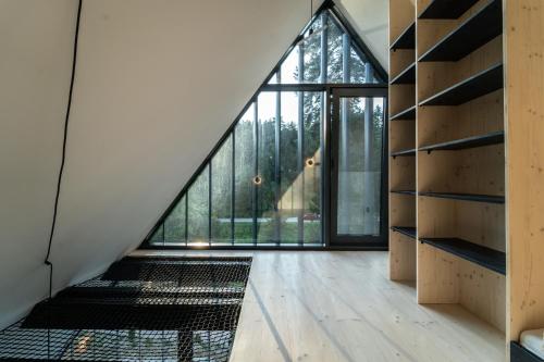 an attic room with a large window and a staircase at Pine chalet in Smižany