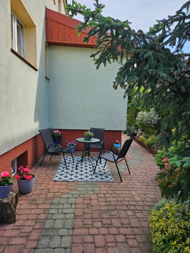 d'une terrasse en briques avec 2 chaises et une table. dans l'établissement Domek letniskowy na Mazurach, à Mrągowo