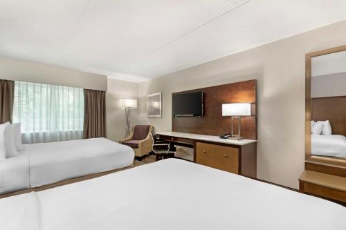 a hotel room with two beds and a desk at Best Western Plus Longbranch Hotel & Convention Center in Cedar Rapids