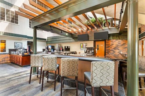 a bar in a restaurant with chairs and a counter at Best Western Plus Longbranch Hotel & Convention Center in Cedar Rapids