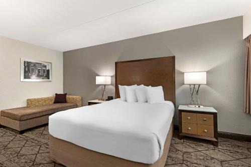 a hotel room with a large bed and a couch at Best Western Plus Longbranch Hotel & Convention Center in Cedar Rapids