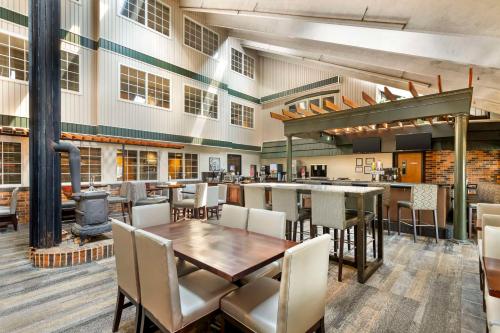 a restaurant with a table and chairs and a stove at Best Western Plus Longbranch Hotel & Convention Center in Cedar Rapids