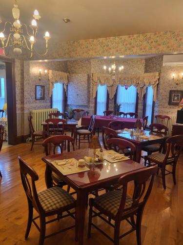 a restaurant with tables and chairs in a room at Cranberry Cove Inn in Louisbourg