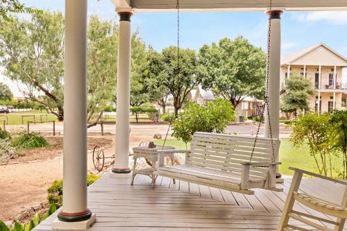 a swinging bench on a porch with a house at #12 The Gruene Room at Garrison in Gruene in New Braunfels