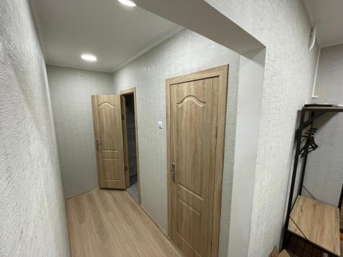a hallway with two wooden doors in a room at Baltijos Apartment in Kaunas