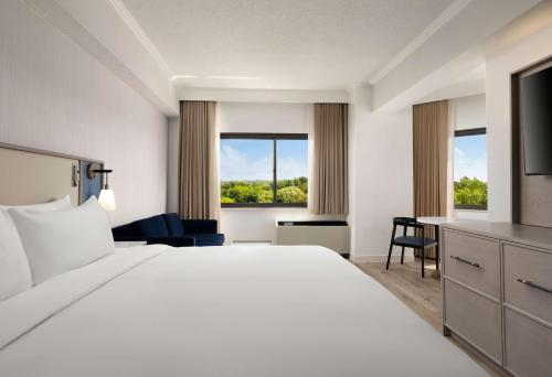 a hotel room with a large bed and a desk at Sonesta White Plains Downtown in White Plains