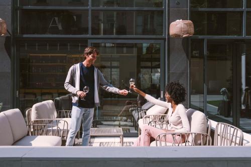 a man and a woman holding glasses of wine at Hotel Yac Paris Clichy, a member of Radisson Individuals in Clichy