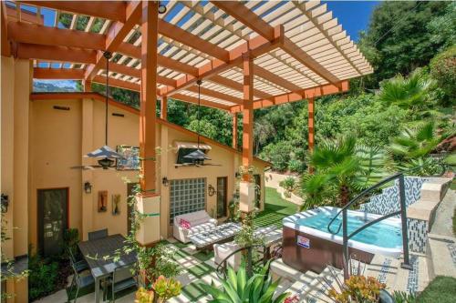 an outdoor patio with a pool and a wooden pergola at Skyhill Oasis New Lux Designer Modern in Los Angeles