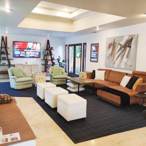 a living room with a couch and tables and chairs at Skyhill Oasis New Lux Designer Modern in Los Angeles