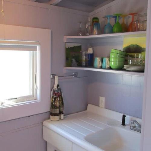 a white bathroom with a sink and a window at Peaceful Waterfront Beach Cottage! in Truro