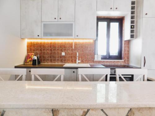 a kitchen with white cabinets and a counter top at Cozy Karuč Home in Cetinje