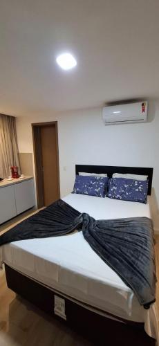 a bedroom with a large bed with blue pillows at Flat Maravilhoso na Praia de Cabo Branco in João Pessoa