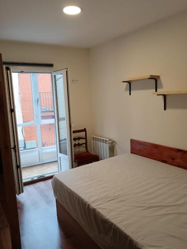 a bedroom with a bed and a sliding glass door at Piso céntrico en Santander in Santander