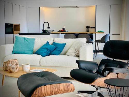 a living room with a white couch and blue pillows at Homely Basel Airport in Saint-Louis