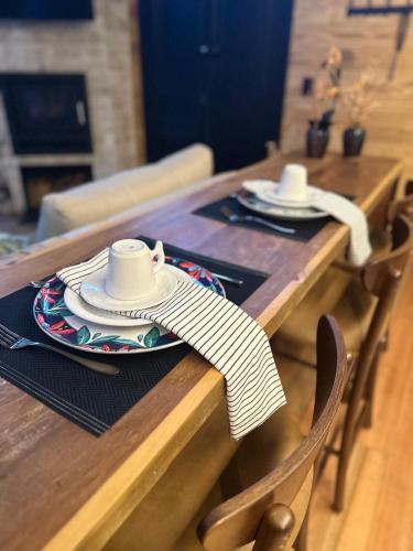 a wooden table with a plate with a cup on it at SEGREDO do VALLE - BOSQUE in Urubici