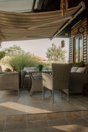 an outdoor patio with wicker chairs and a table at Kuća Luna in Gornji Milanovac