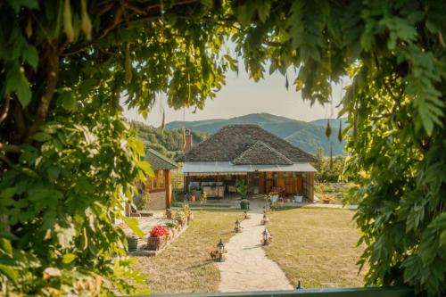 a house in a field with mountains in the background at Kuća Luna in Gornji Milanovac