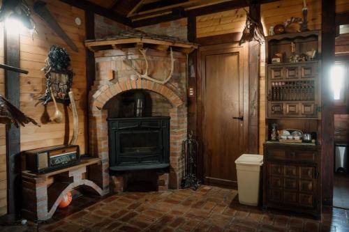 a room with a brick fireplace and a stove at Kuća Luna in Gornji Milanovac