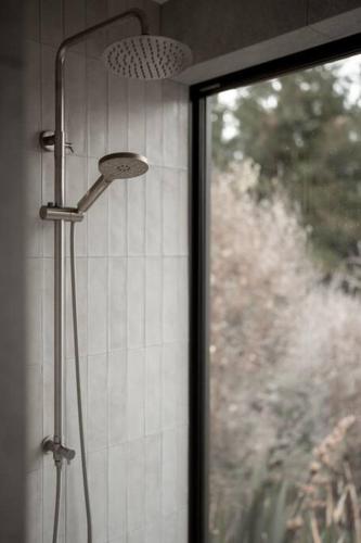 a shower in a bathroom next to a window at The Pines Guesthouse - new re-list in Arrowtown