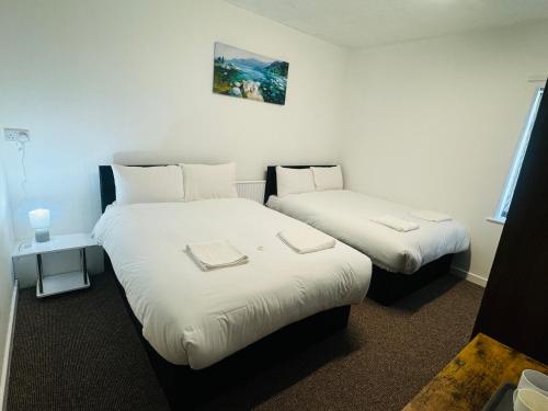 two beds in a room with white sheets at Tower Central hotel Albert Road in Blackpool